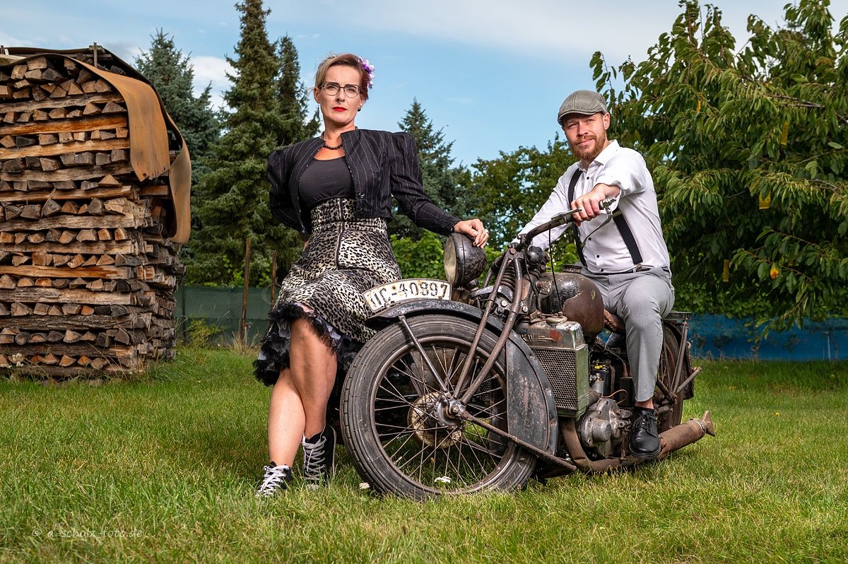 Historisches Motorrad mit zwei Personen bei einer Vereins-Fotoaufnahme